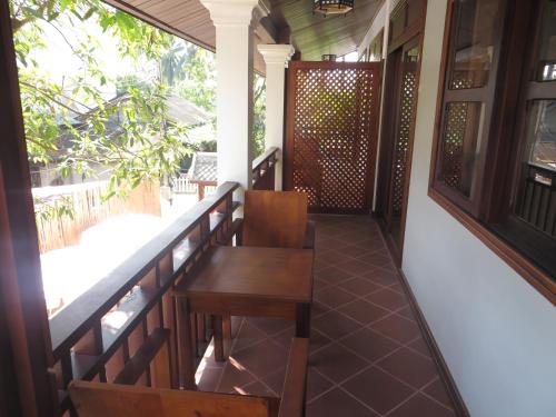a balcony of a house with a table and chairs at QUEEN'S HOUSE in Luang Prabang