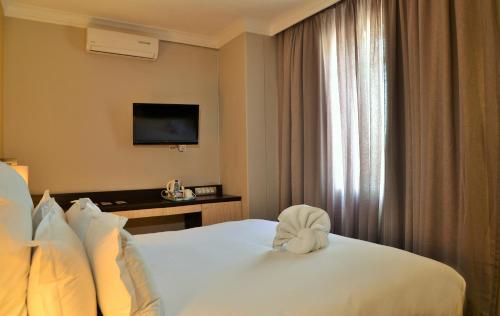 a hotel room with a bed and a television at Cresta Oasis Hotel in Harare