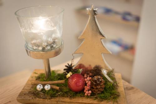 a miniature christmas tree sitting on a table next to a glass at Fernerblick Apartments in Tux