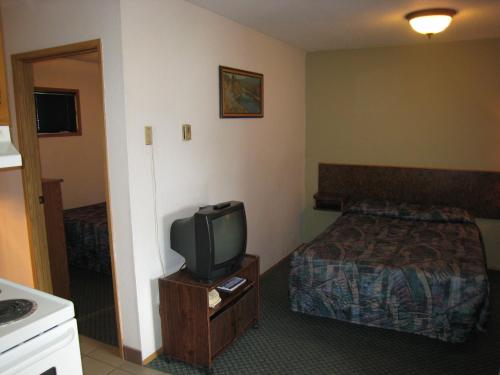 a hotel room with a bed and a tv at Swiss Village Inn in Golden
