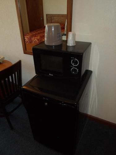 a microwave sitting on top of a table in a room at Economy Inn Morgan Hill in Morgan Hill