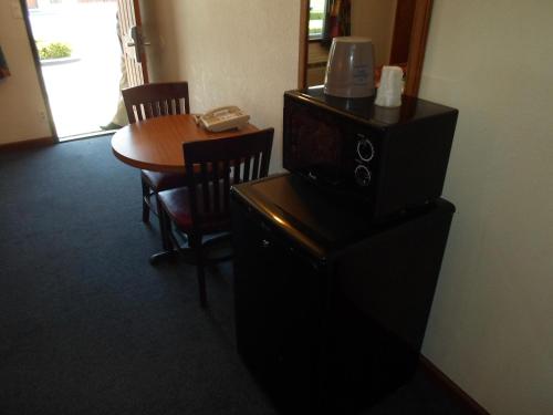 a room with a table and a television on a stand at Economy Inn Morgan Hill in Morgan Hill