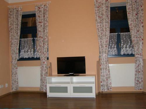 een woonkamer met 2 ramen en een flatscreen-tv bij Apartment Jakubske Namesti in Česká Kamenice