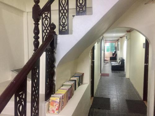 a hallway with a staircase with books at Golden Bee PhiPhi in Phi Phi Don