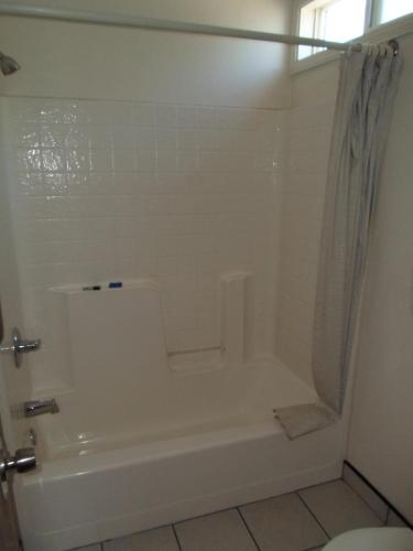a bathroom with a white tub and a shower at Economy Inn Morgan Hill in Morgan Hill