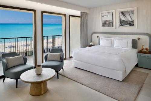 a bedroom with a bed and a balcony with the ocean at Al Alamein Hotel in El Alamein