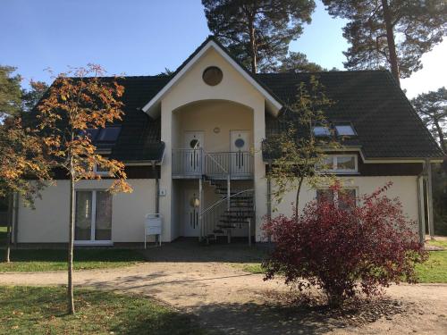 a large white house with a porch and stairs at Ferienhaus Ostseestern in Trassenheide