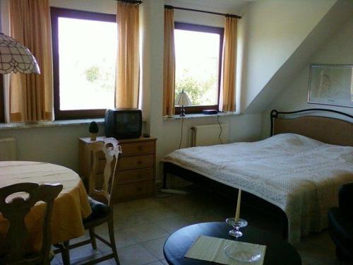 um quarto com uma cama, uma mesa e uma televisão em Haus-Halligblick-Ferienwohnungen-am-Meer em Dagebüll