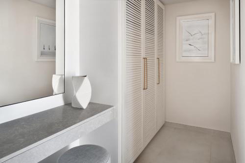 a bathroom with white walls and a pivot door at Al Alamein Hotel in El Alamein