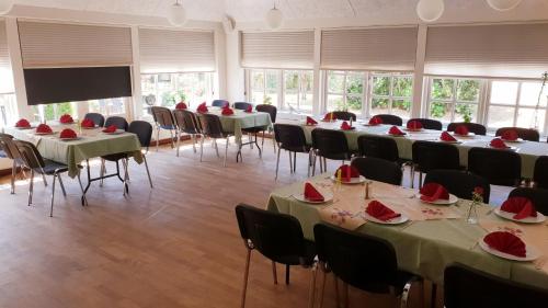 a room with tables and chairs and a projection screen at Hodde Kro in Tistrup
