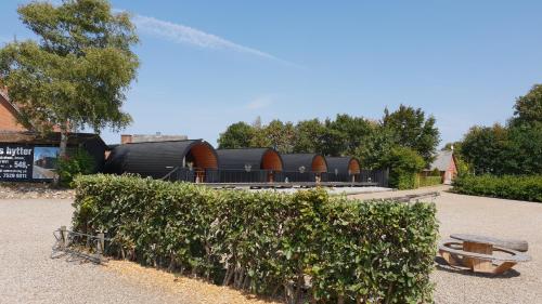 a hedge in front of a building with a bench at Hodde Kro in Tistrup