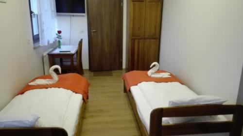 two beds in a room with a table and a desk at Willa Julia in Kraków