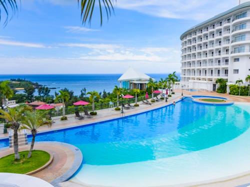 a large swimming pool in front of a building at Okinawa Kariyushi Beach Resort Ocean Spa in Onna