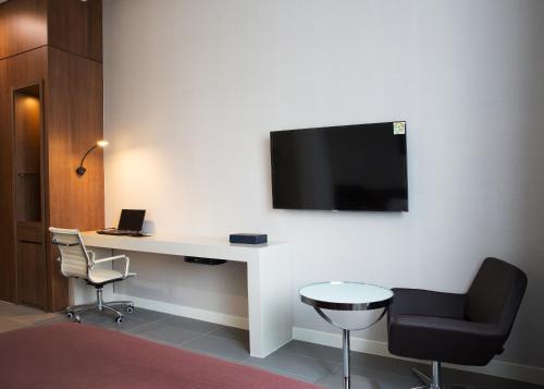 a room with a desk and a tv on a wall at Hotel Mate Bundang in Seongnam
