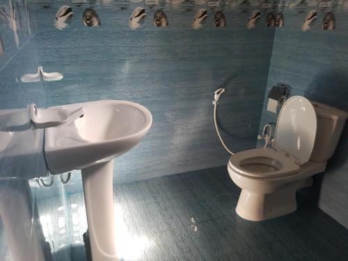 a bathroom with a toilet and a sink at Sea Port Hiriketiya in Hiriketiya