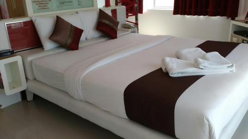a large white bed with two folded towels on it at Hinnam Saisuay by One in Hua Hin