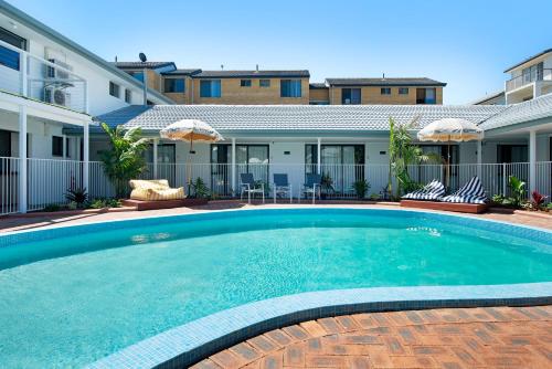 a swimming pool in front of a building at Blue Heron Boutique Motel in Gold Coast