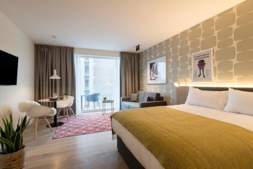 a hotel room with a bed and a living room at PREMIER SUITES Antwerp in Antwerp