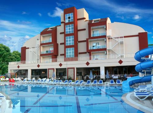 un hotel con piscina y sillas frente a un edificio en Side West Park Hotel, en Side