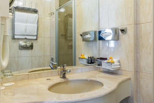 y baño con lavabo y espejo. en My City Hotel, en Tallin