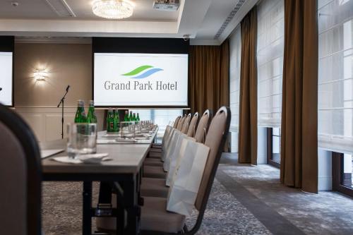a long table in a room with chairs and a screen at Grand Park Hotel in Szczecin