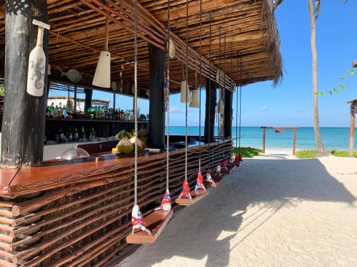 a bar on the beach with a view of the ocean at The Sands Beach Resort in Bwejuu