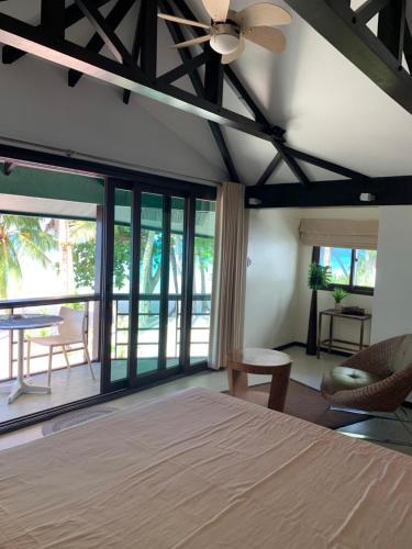 a bedroom with a bed and a ceiling fan at Boracay Beach Houses in Boracay