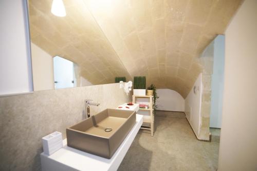 a bathroom with a white sink and a sink at Petra Mater Casa Vacanze in Matera