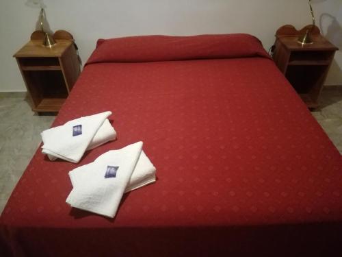 een rood bed met witte kussens erop bij White Field Houses and Spa in Villa Las Rosas