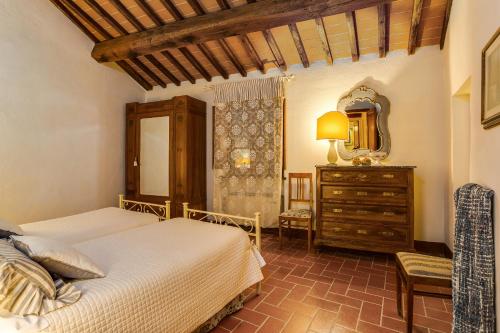 a bedroom with two beds and a dresser and a mirror at Romitorio di Serelle in Barberino di Val dʼElsa