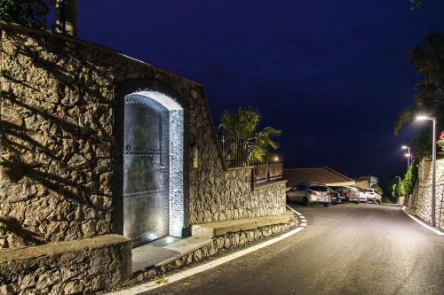 a stone wall with an arch on the side of a street at Villa Zagara Garden Spectacular Sea View in Taormina in Taormina