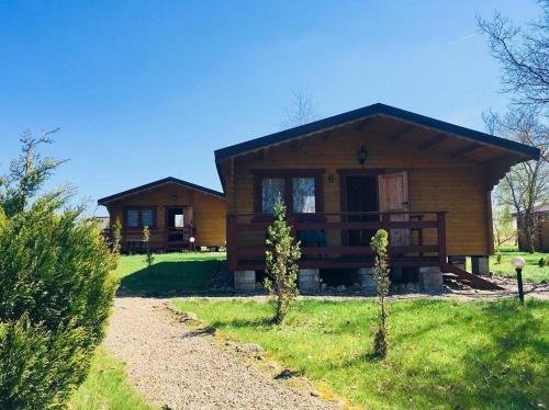 a large wooden house with a pathway in front of it at Domki Letniskowe Kalem in Zabin
