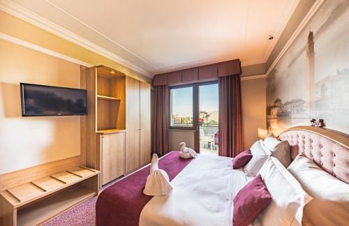 a hotel room with a bed and a tv at Villa Fiorita in Monastier di Treviso
