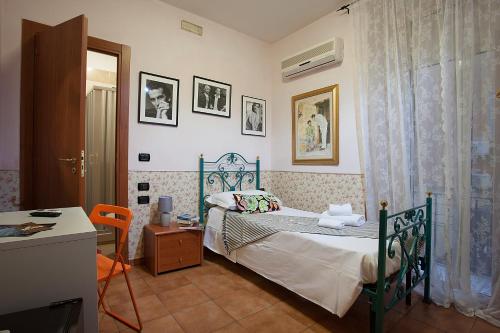 a bedroom with a bed and a table and a desk at Hotel Cineholiday in Naples