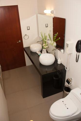 a bathroom with two sinks and a mirror at Sunec Hotel in Chiclayo