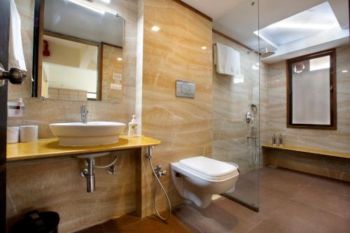 a bathroom with a toilet and a sink and a shower at SaffronStays Nithyam, Vikramgad in Pālghar
