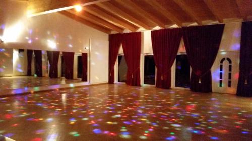 eine leere Tanzfläche mit roten Vorhängen und Lampen in der Unterkunft Landhotel kreien in Kreien