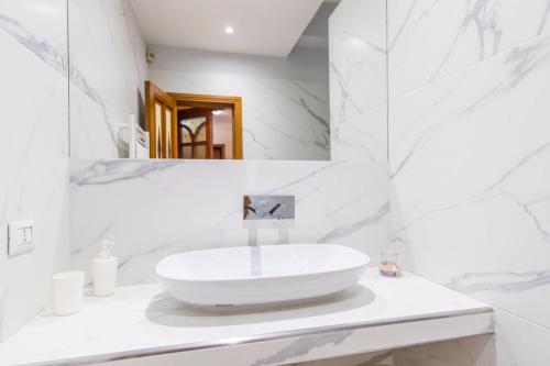 a white bathroom with a sink and a mirror at B&b Il miglio d’oro in Ercolano