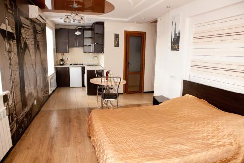 um quarto com uma cama, uma mesa e uma cozinha em Aparmtnet City Center em Vinnytsya