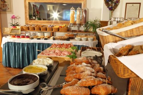 アンダロにあるHotel La Baitaの様々なペストリーやその他の食品を取り揃えたビュッフェ