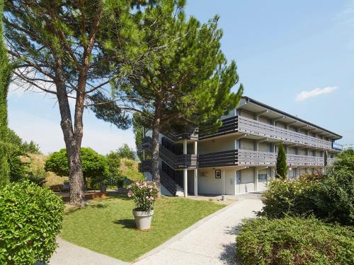 a building with trees in front of it at Kyriad Digne-Les-Bains in Digne-les-Bains