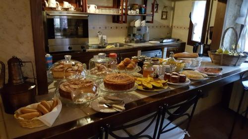 a kitchen counter with many different types of cakes and pastries at Posada el Campanario in Rascafría