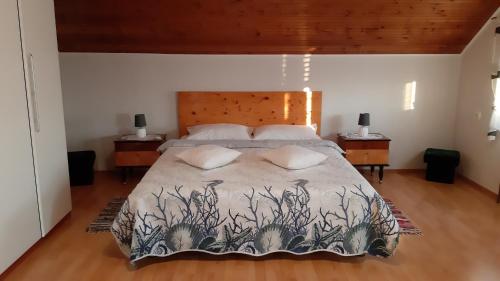 een slaapkamer met een groot bed met 2 kussens bij Rooms & Apartments Amelee in Zagreb