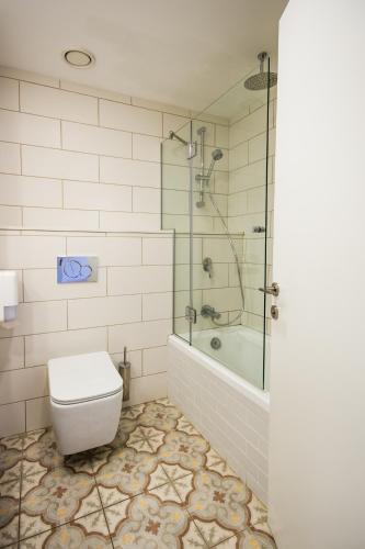 a bathroom with a shower and a toilet and a tub at Kinar Galilee in Kinar