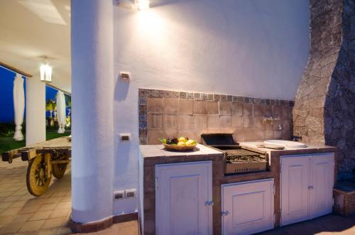 a kitchen with a stove and a bowl of fruit on the counter at Luxury Taorum villa with spectacular sea views in Taormina in Taormina