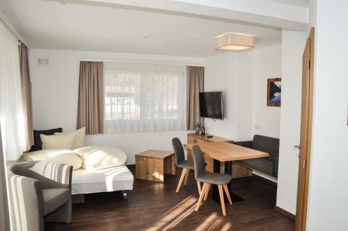 ein Hotelzimmer mit einem Bett, einem Schreibtisch und einem Tisch in der Unterkunft Bergruh Steeg in Steeg