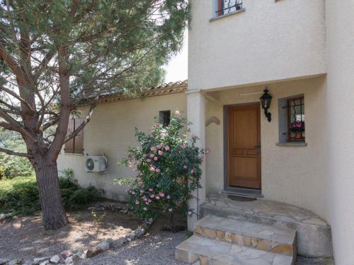 una casa con un árbol y un arbusto con flores rosas en Modern villa with private pool, en Félines-Minervois