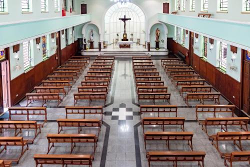 an empty church with wooden benches in the aisle at Eventos & Hospedagem Sagrada Família in Sao Paulo