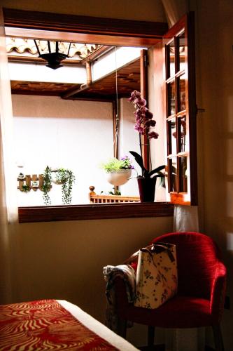 a room with a window with a chair and flowers at Il Sogno di Gio de la Laguna in La Laguna