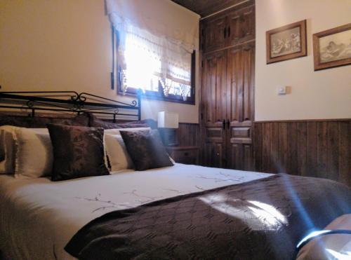 a bedroom with a large bed with wooden walls at Posada el Campanario in Rascafría
